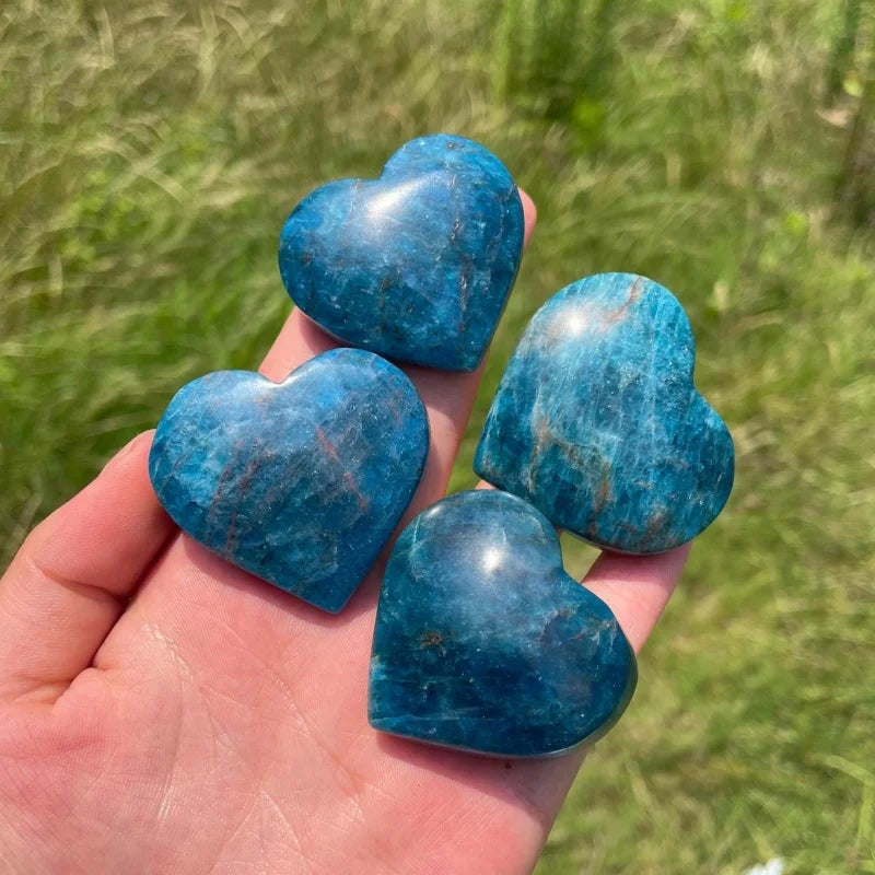 Blue apatite heart carvings in hand